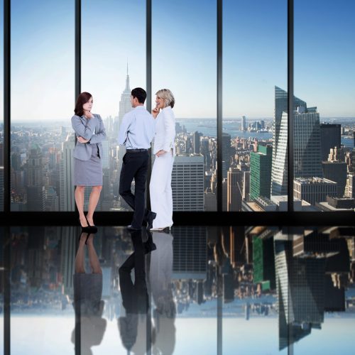 Business colleagues talking in large room overlooking city